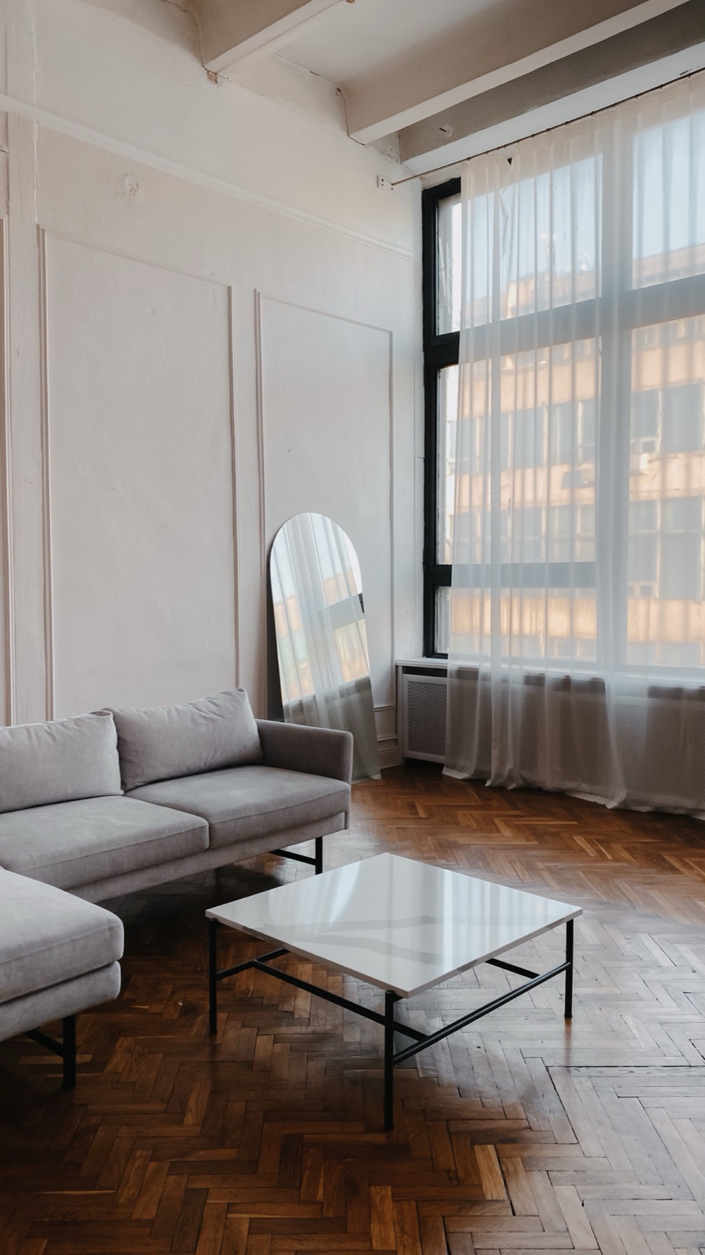 Floor-to-ceiling sheer curtain panels in a sunlit living room